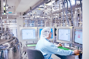 Un employé d'une usine pharmaceutique surveille les données de fabrication en temps réel