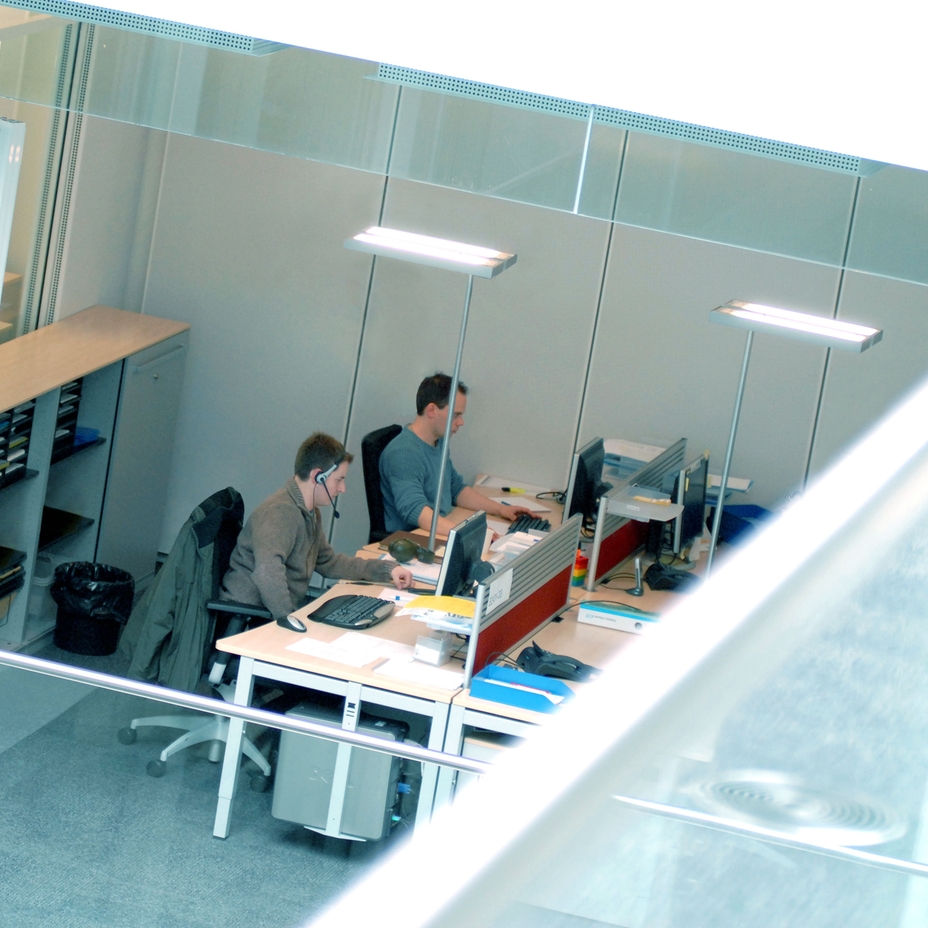 Blick von oben auf zwei Ingenieure, die an ihren Schreibtischen arbeiten
