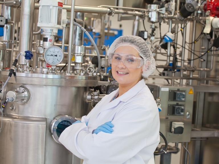 Anlagenbedienerin in einer Reinraum-Produktionsanlage für Biowissenschaften