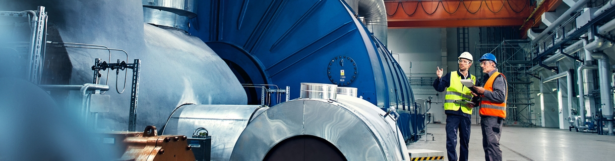 Close-up picture of an engineer in front of a turbine in a power plant