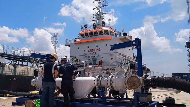 Ein Endress+Hauser Master Metering Skid vor einer Bunkerbarge im Hafen von Singapur