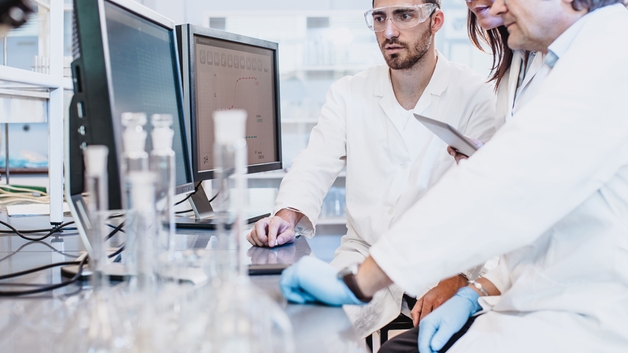 Wissenschaftler, die in einem Labor arbeiten und auf einen Computerbildschirm schauen