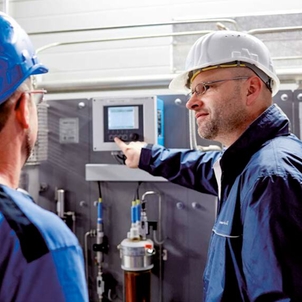 Techniker vor einer SWAS-Anlage (Steam Water Analysis System)