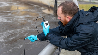 Tecnico che verifica un punto di misura con un misuratore di ossigeno disciolto (DO) portatile