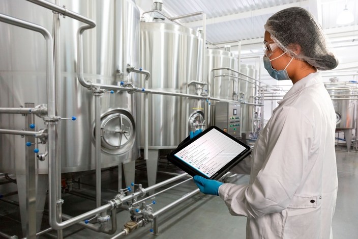 Femmes devant une usine de production agroalimentaire vérifiant le statut de Netilion Asset Health